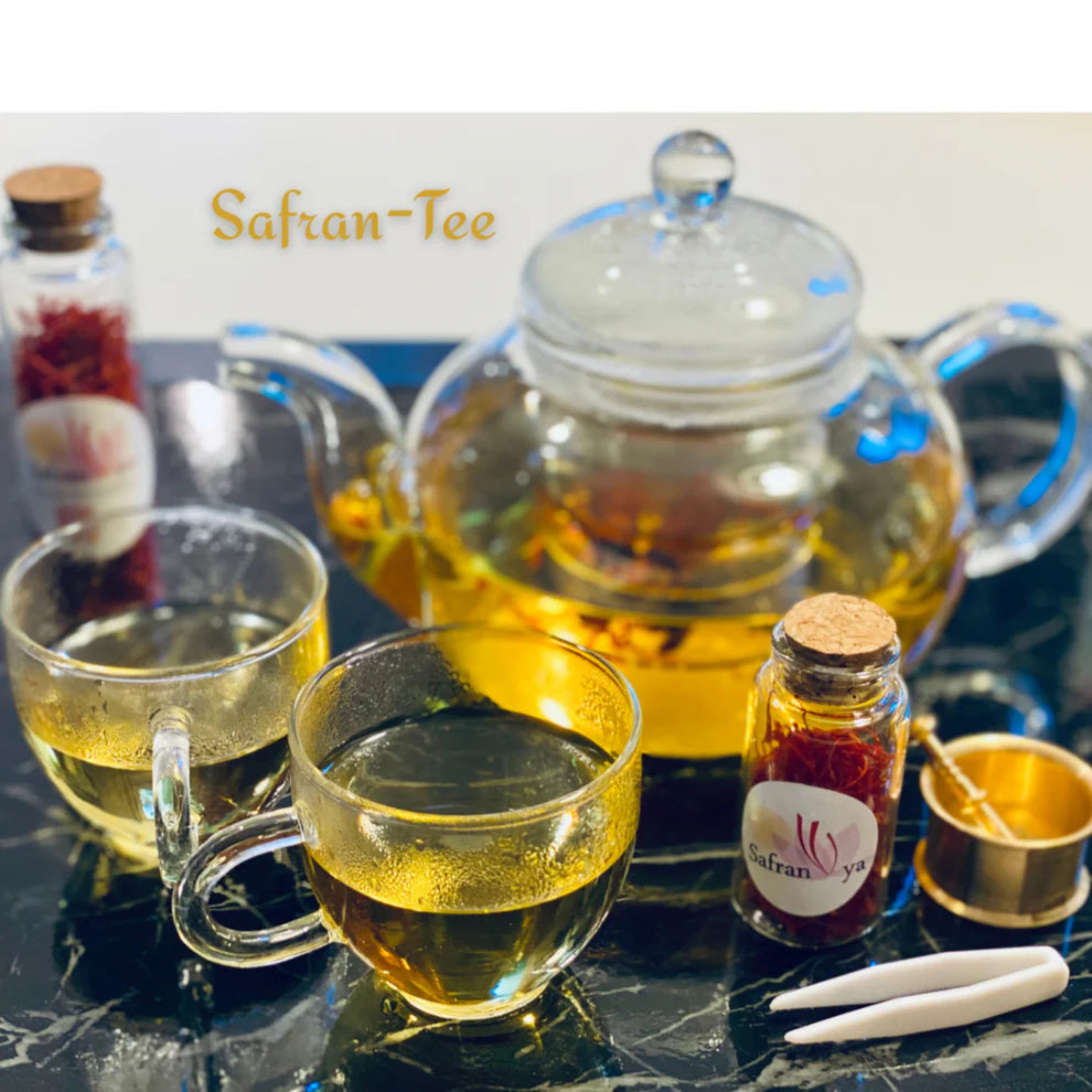 Goldgelber Safran-Tee in Glaskanne mit Tassen, aufgebrüht mit hochwertigen Safranfäden von Safranya