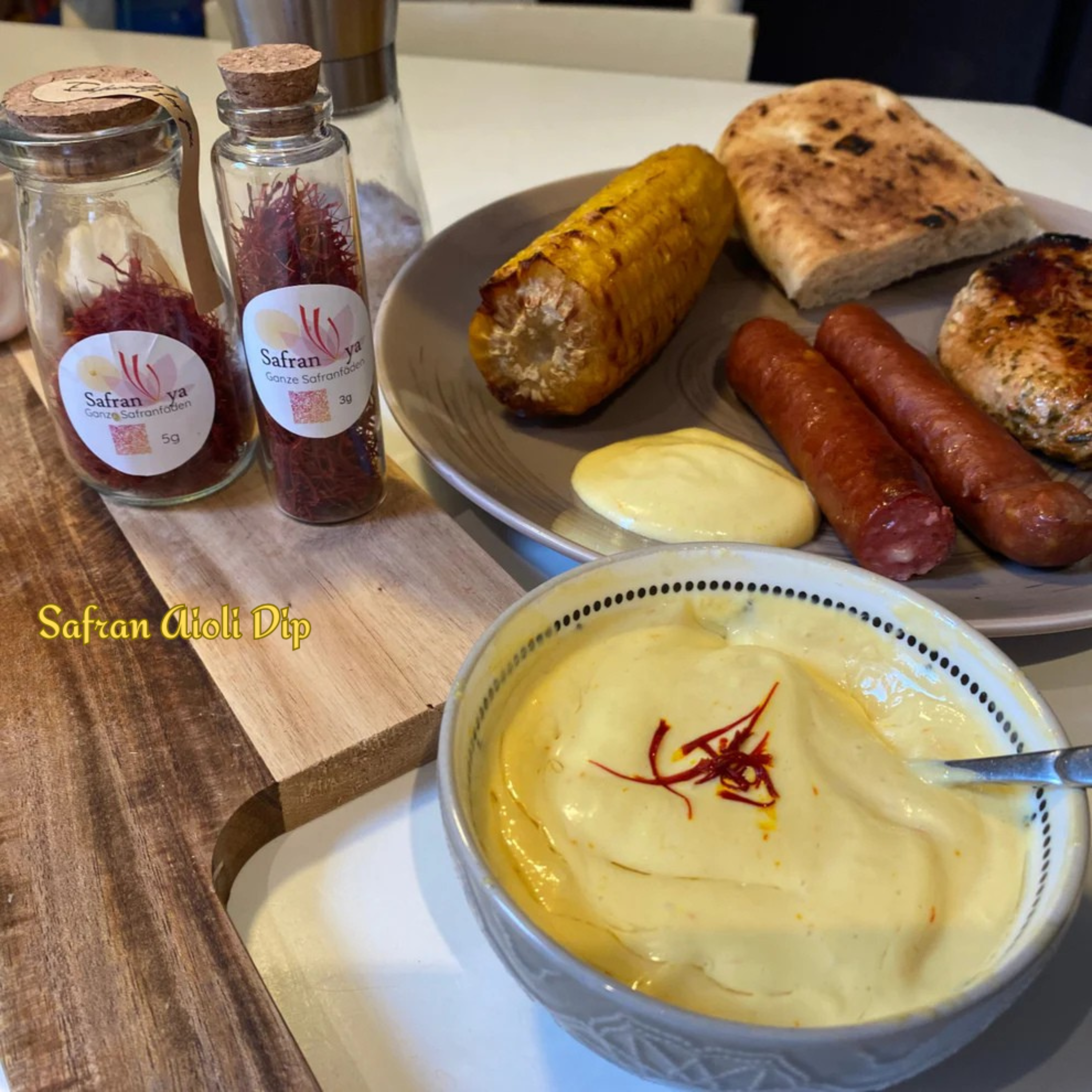Hausgemachter Safran-Aioli Dip mit gegrilltem Fleisch, Mais und Brot, verfeinert mit Safranya Safranfäden
