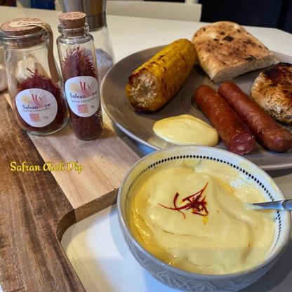 Hausgemachter Safran-Aioli Dip mit gegrilltem Fleisch, Mais und Brot, verfeinert mit Safranya Safranfäden